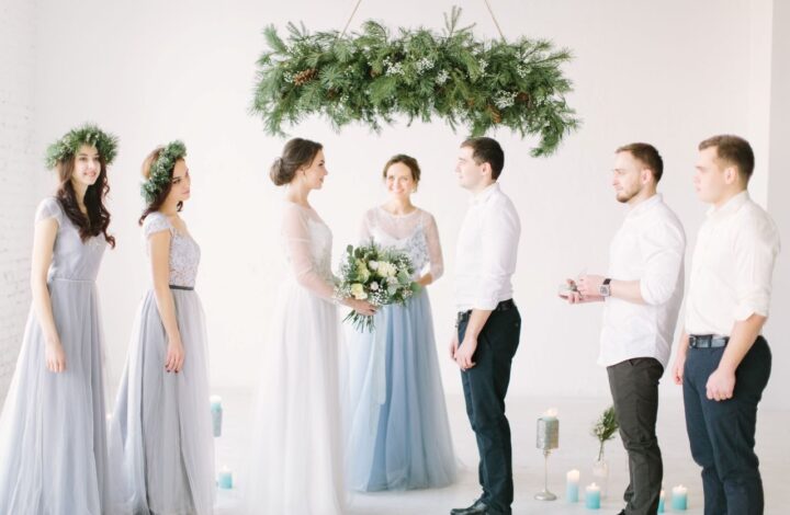 bride and groom stand at altar surrounded by bridal party with wedding officiants