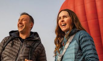 couple laughing while on honeymoon doing community tourism