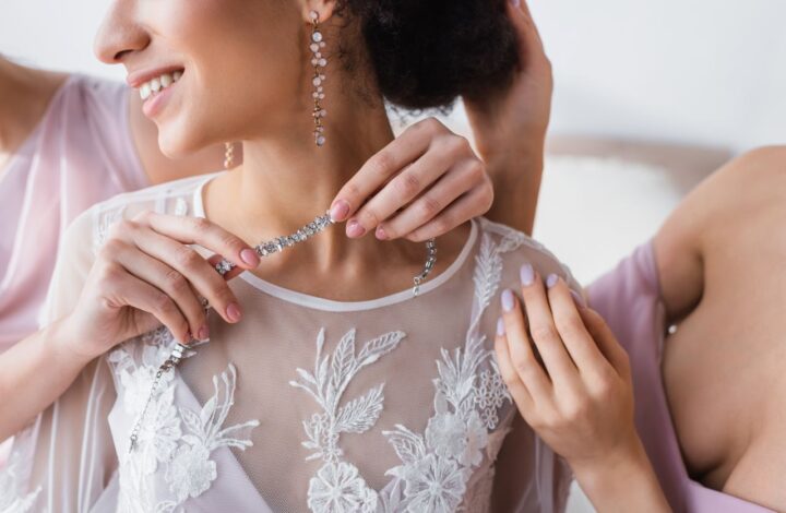 bride portrait getting necklace put on showing long drop earrings