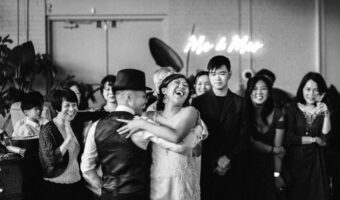 black and white portrait of bride and groom dancing and laughing film-style wedding photography by Loving Care Photography