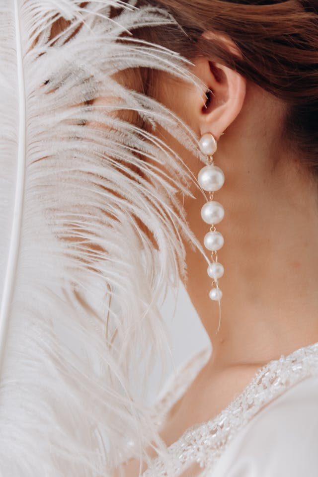 Woman in White Dress Wearing Pearl Earrings after choose wedding jewellery