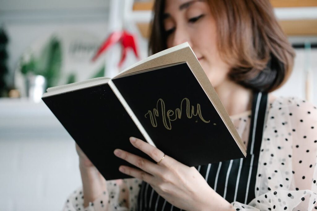 woman writing wedding dinner ideas in wedding menu book creating better weddings