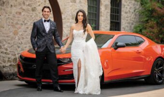 bride and groom pose with red sportscar at Elora Mill Hotel