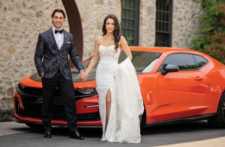 bride and groom pose with red sportscar at Elora Mill Hotel