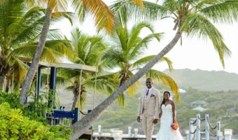 bride and groom stand on dock in Barbuda after buying destination wedding insurance