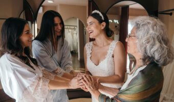 grandma bride and bridesmaids circle holding hands and celebrating after wedding planning