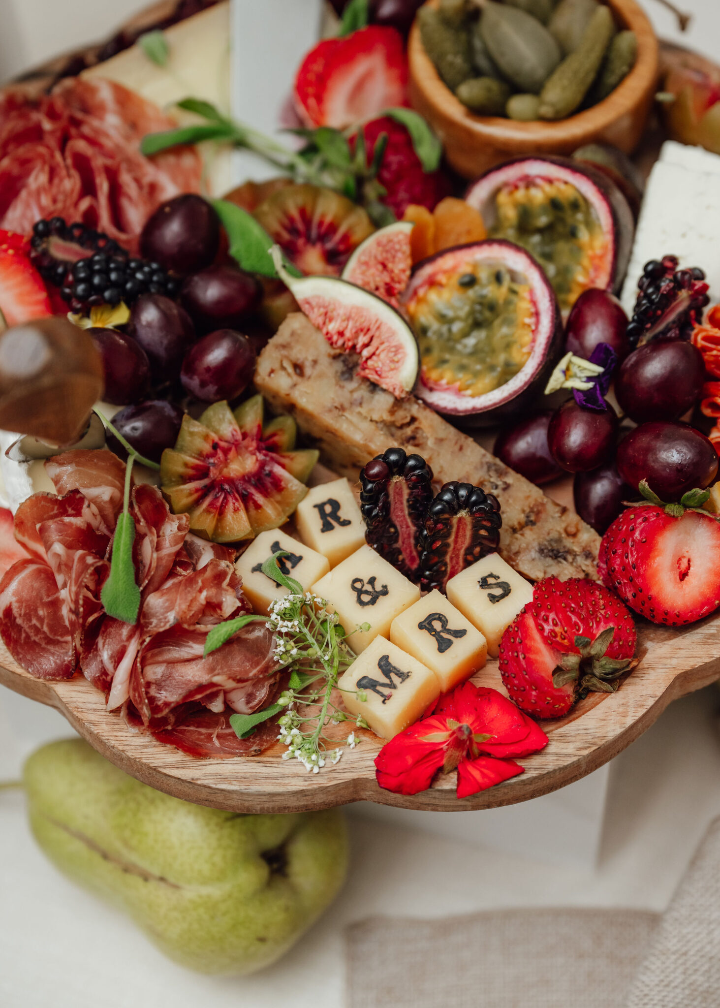 Charcuterie board with meats, cheeses, and a variety of fruits like strawberries, grapes, and figs.