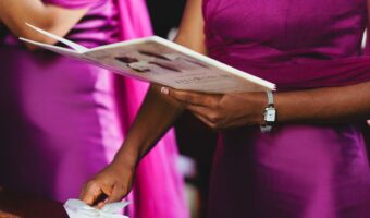 bridesmaid in fuchsia dress holding wedding program one of the wedding details