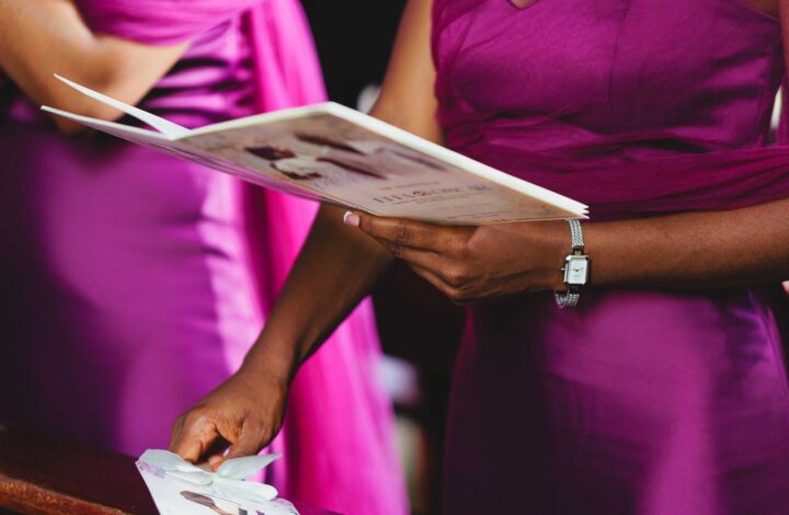 bridesmaid in fuchsia dress holding wedding program one of the wedding details