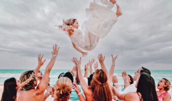 bride tossed in the air by bridesmaids for funny wedding photos