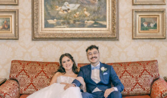 modern and fun Hotel Saskatchewan wedding portrait of bride and groom sitting on antique sofa